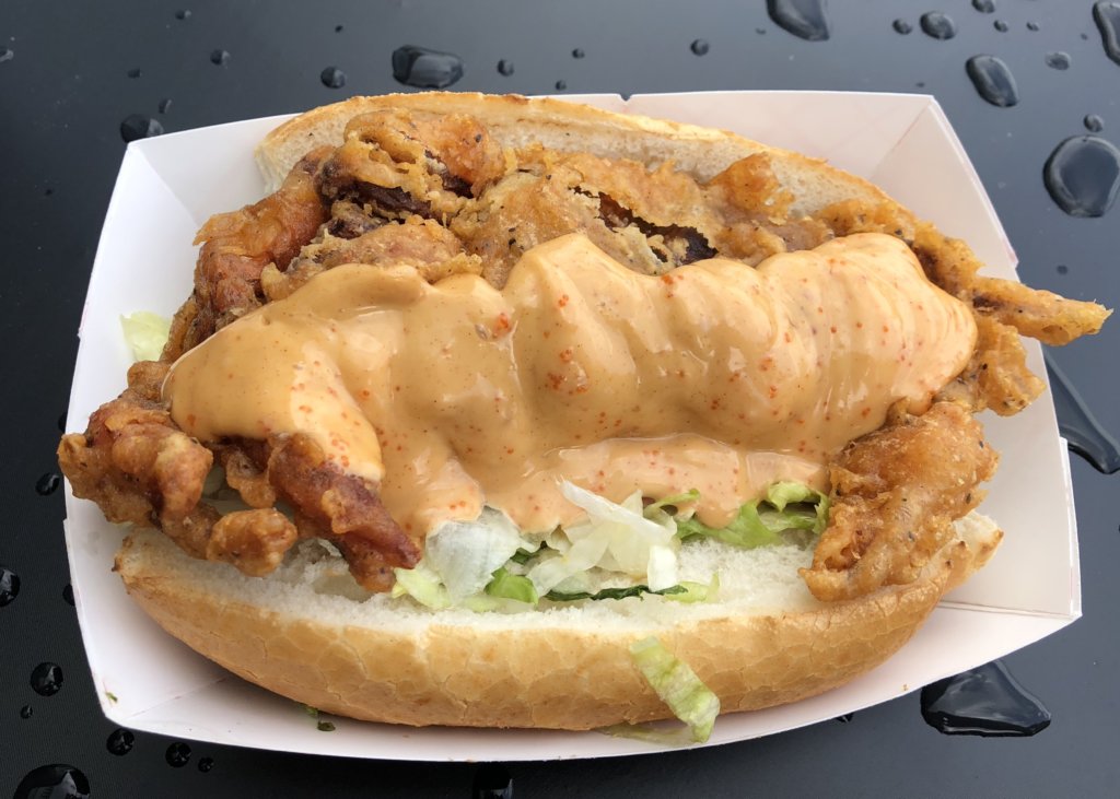 Deep-fried, battered soft-shelled crab covered with Creole sauce, dressed with lettuce on a sub bun. Served in a paper holder.
