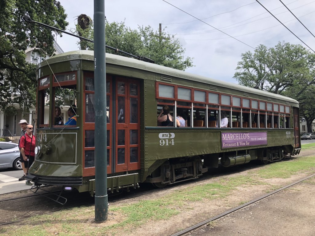 Old, green streetcar (cablecar) loading up passengers in New Orleans.