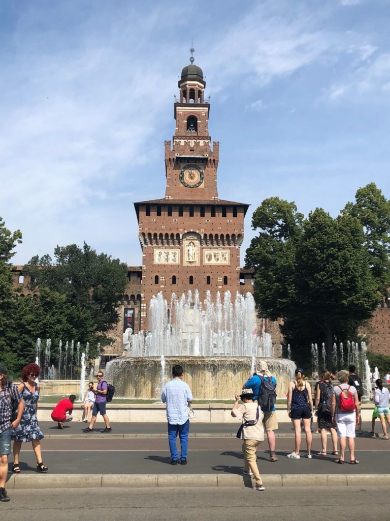 Sforza Castle with fountain and people walking around