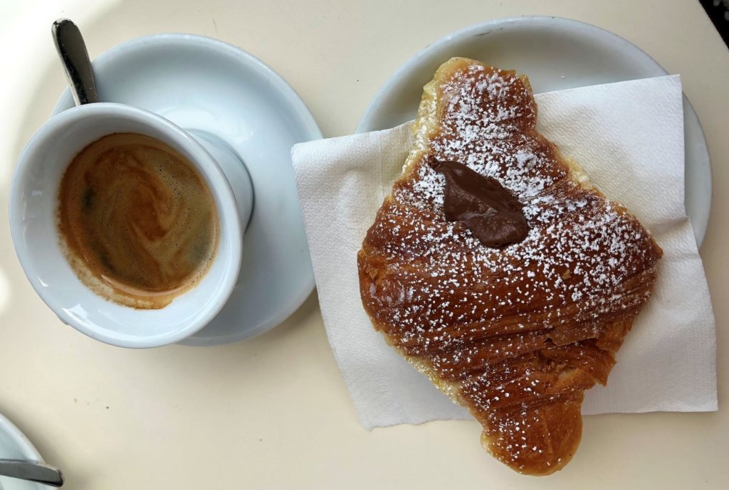Coffee and nutella croissant dusted with powdered sugar in Ostia, Italy