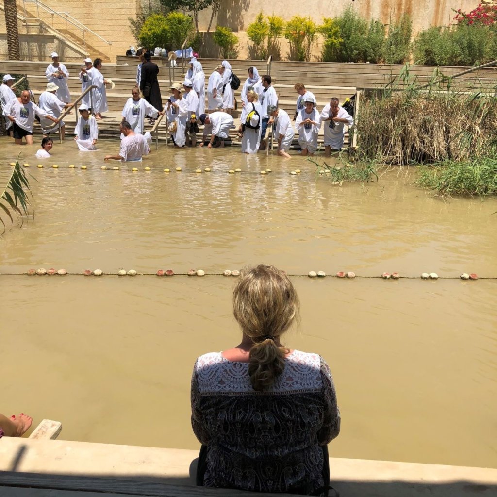 Dipping my feet in the Jordan River while watching baptisms on the Israel side.