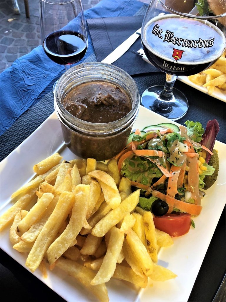 Enjoying a glass of red wine, traditional Flemish stew, salad and frites. Darryl, of course, has a beer.