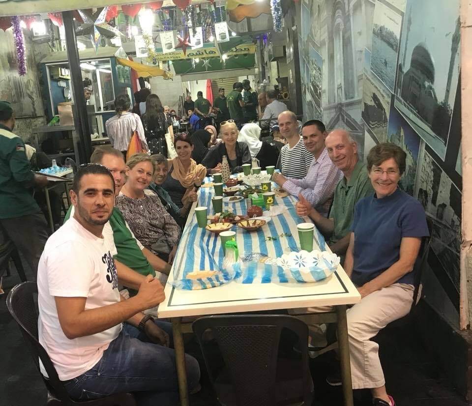 Group of people eating falafel at an open air restaurant in Amman, Jordan