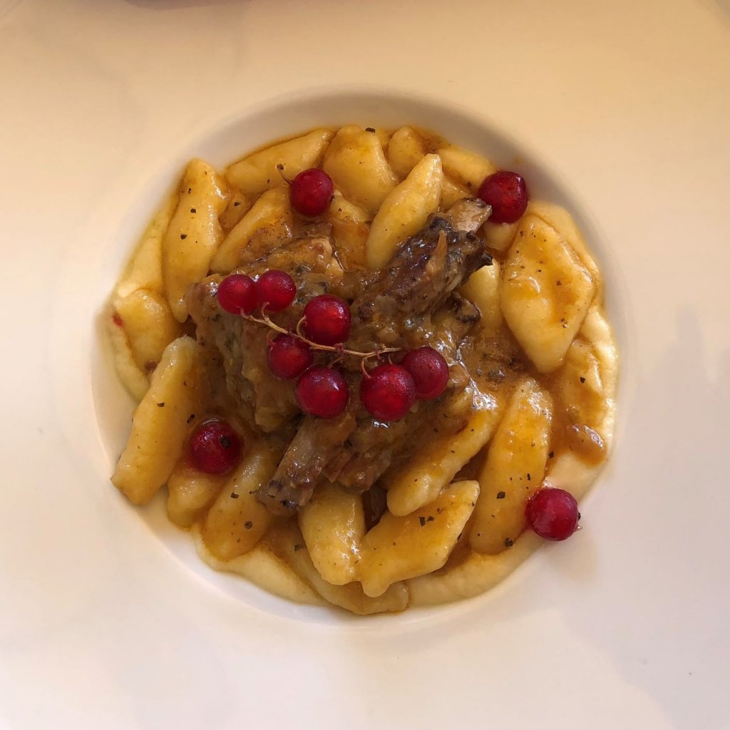 gnocchi and boars ribs with red berries as a garnish