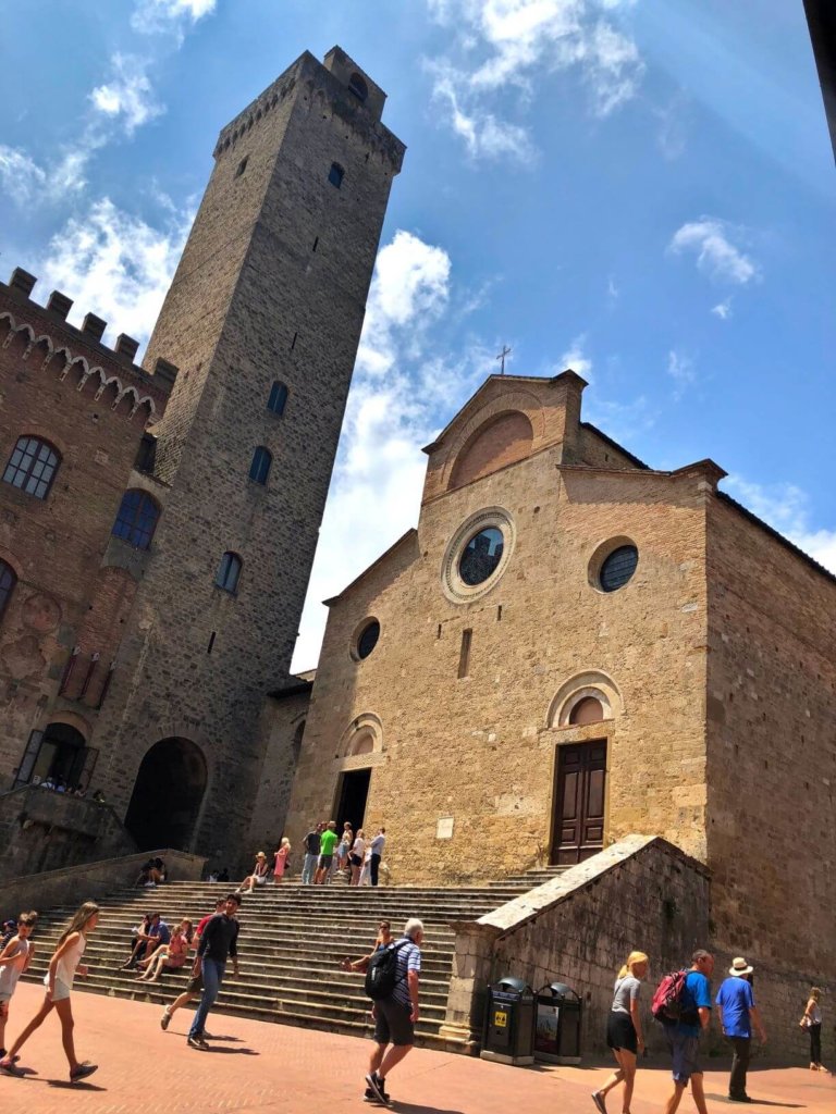 The Duomo in San Gimignano with tower and tourists