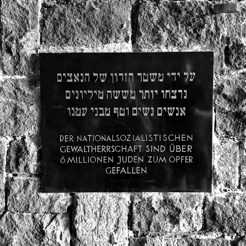 A stone sign along a brick wall