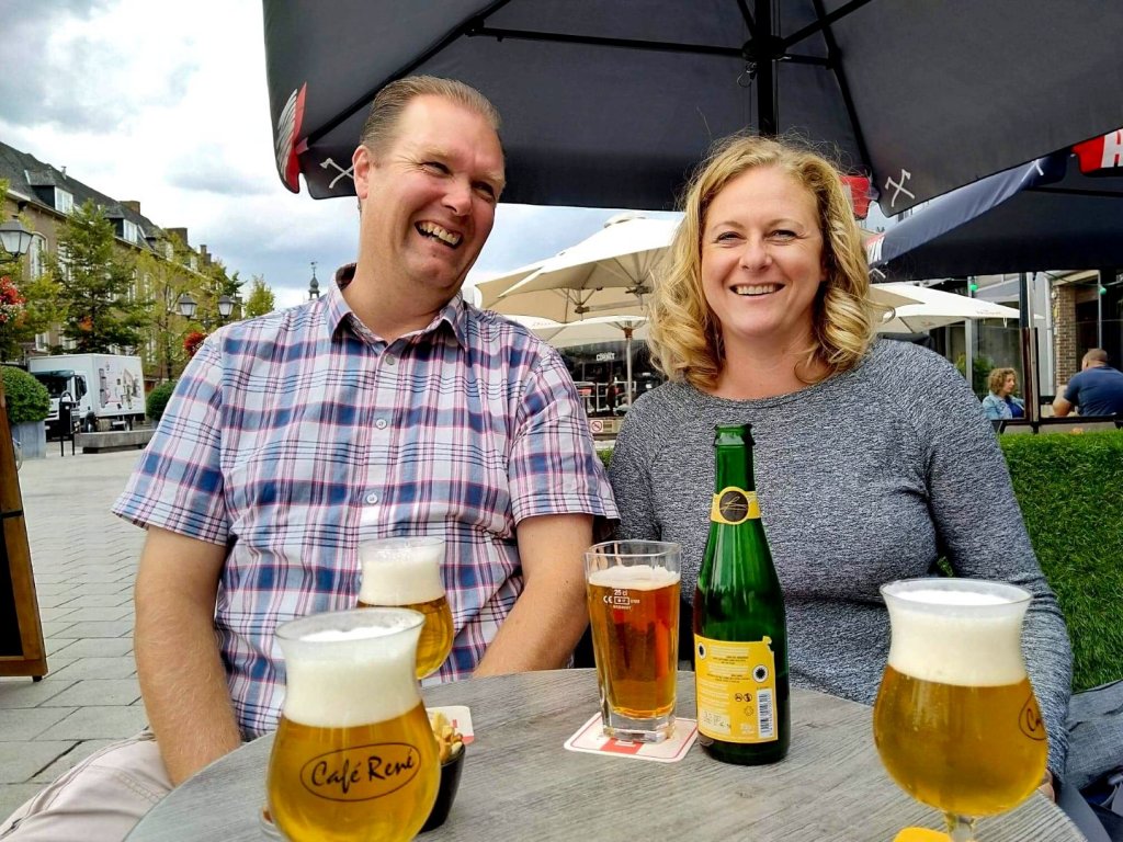 Two smiling people enjoying a beer at Cafe Rene in Lier, Belgium