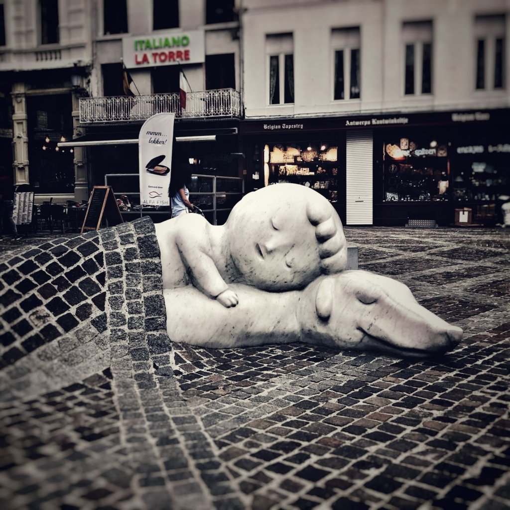 Statues of Nello and Patrasche from A Dog of Flanders under a cobblestone blanket in Antwerp, Belgium