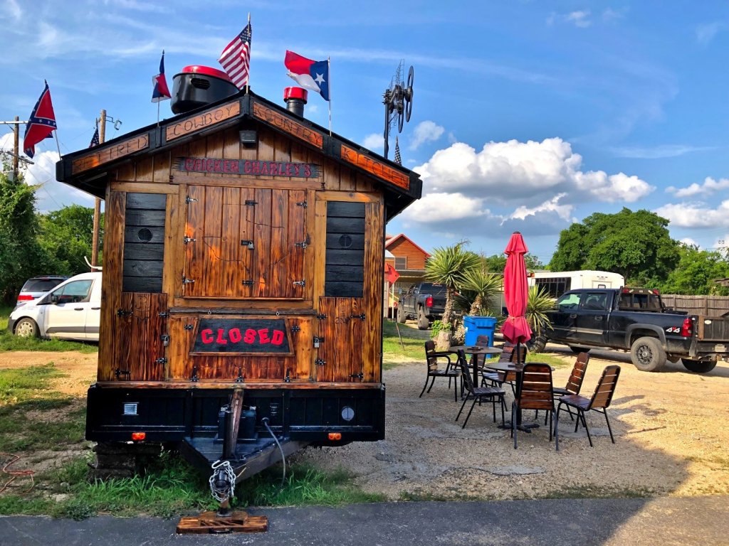 wooden small restaurant on wheels with patio chairs and tables out front