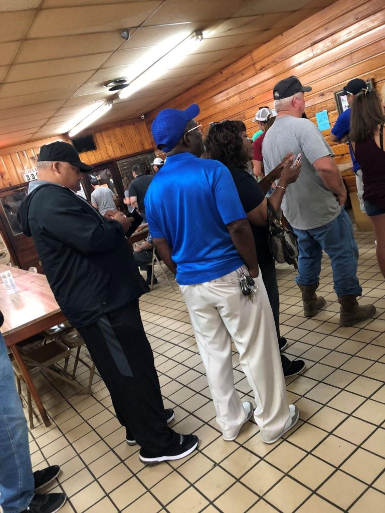 people lined up in a restaurant for food.
