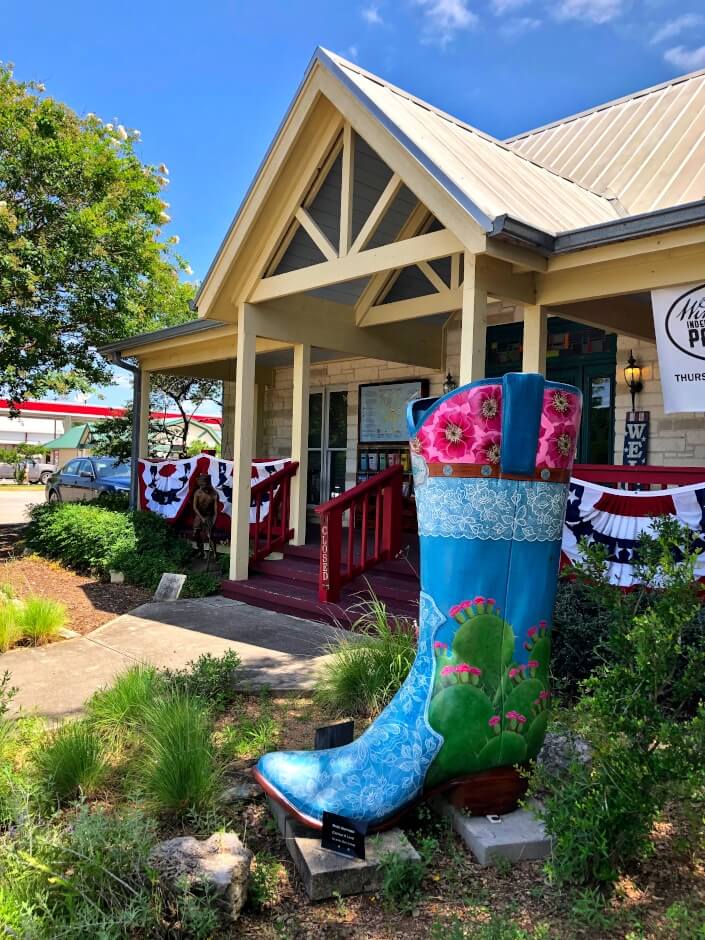 A big painted blue cowboy boot in front of tourist information in Wimberley, Texas