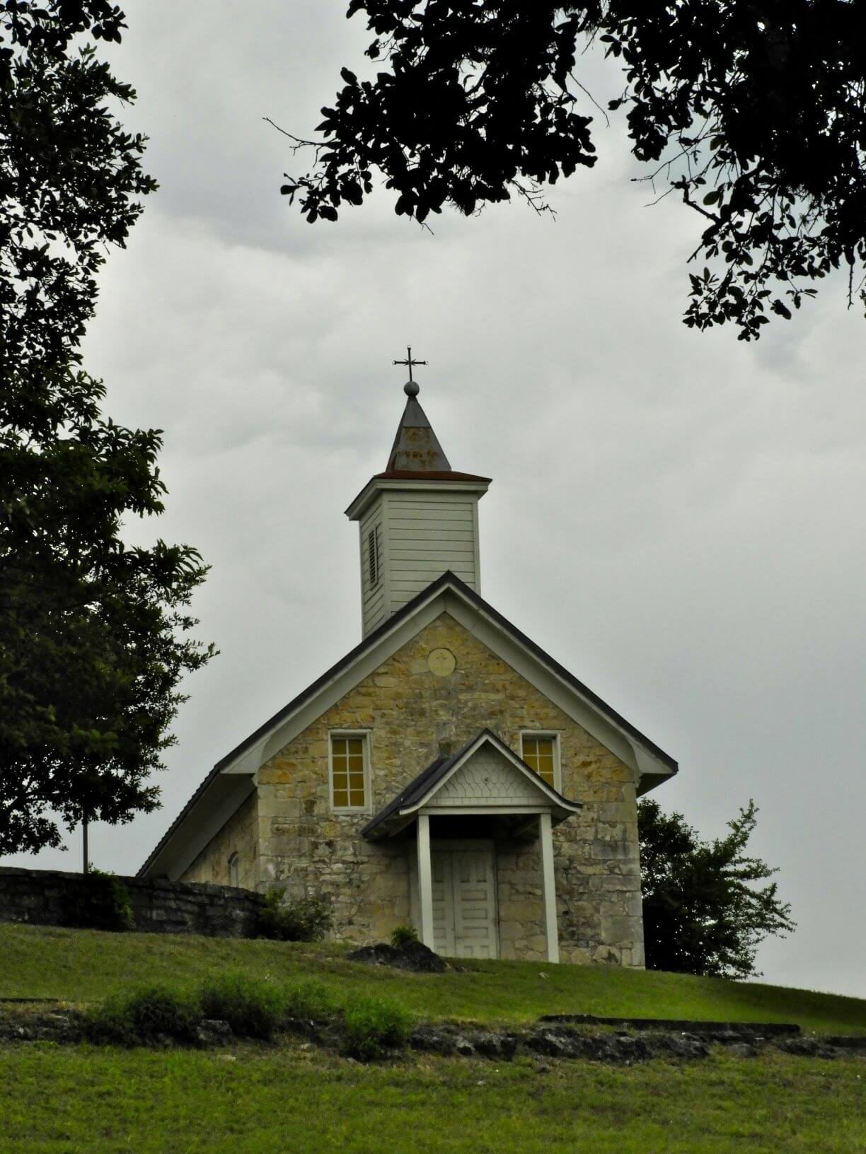 small church with steeple sits on a small hill