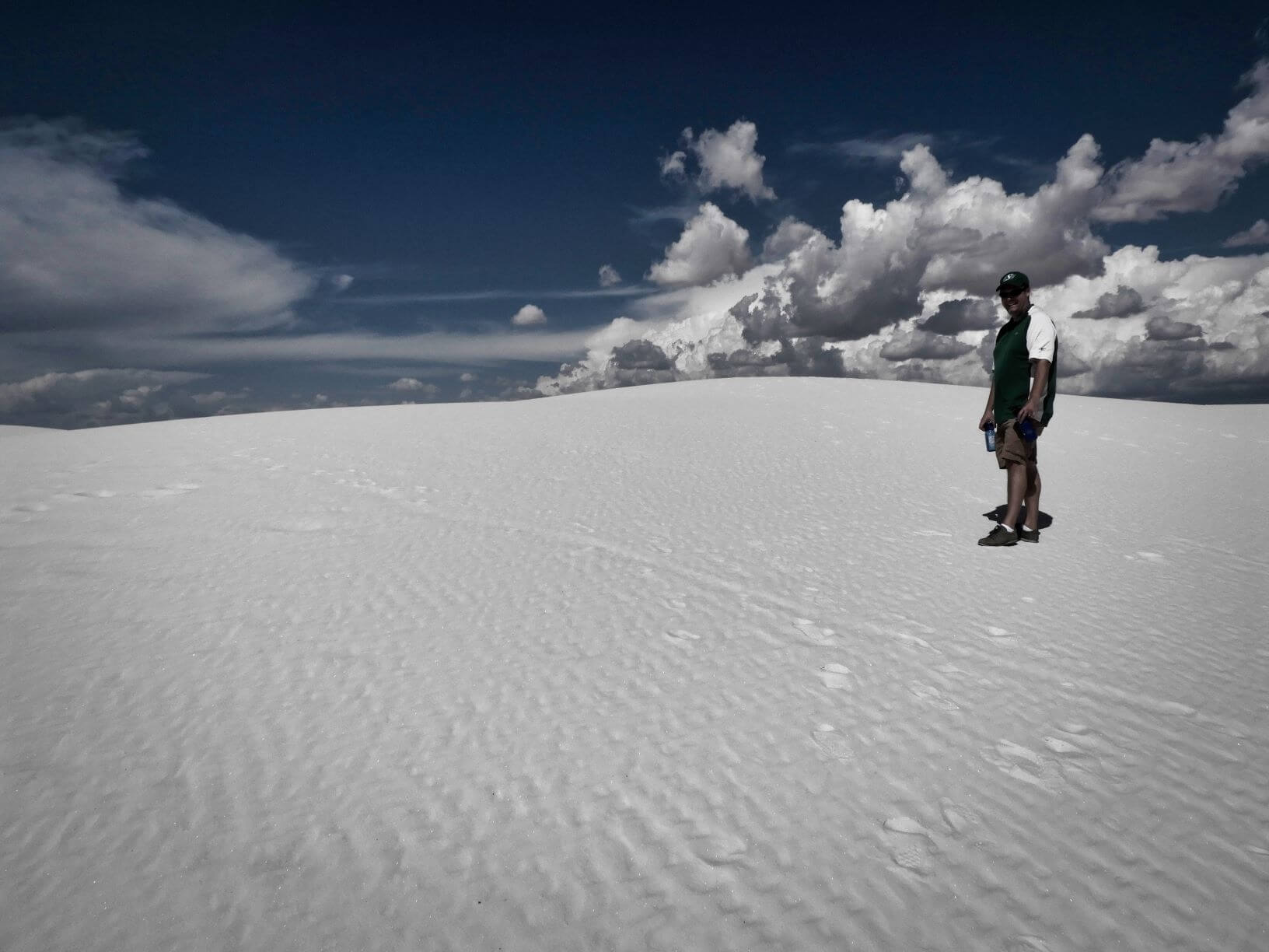 White sand dunes, sky, and a man standing on the dunes
