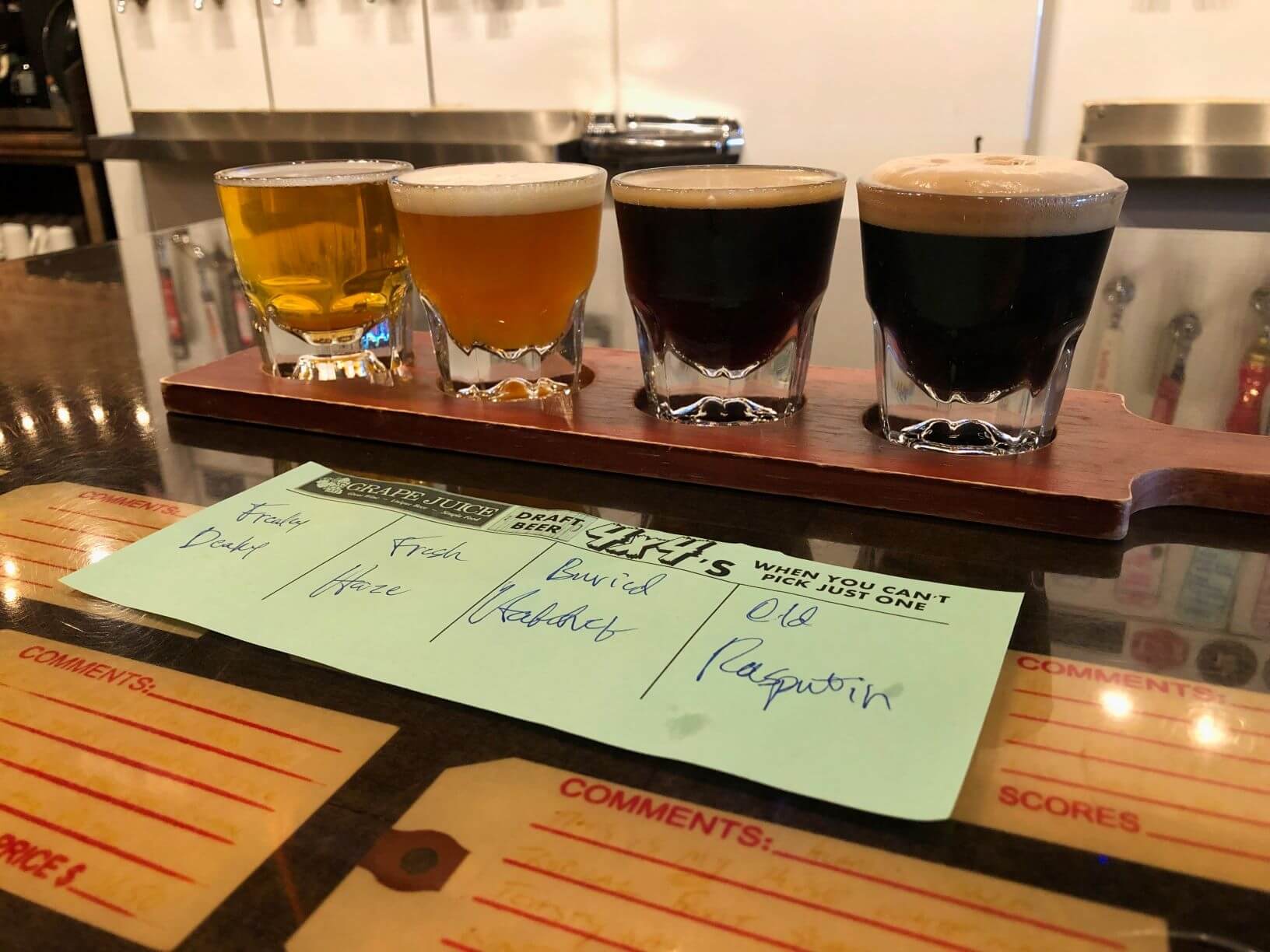 a line up of a flight of beers on a bar