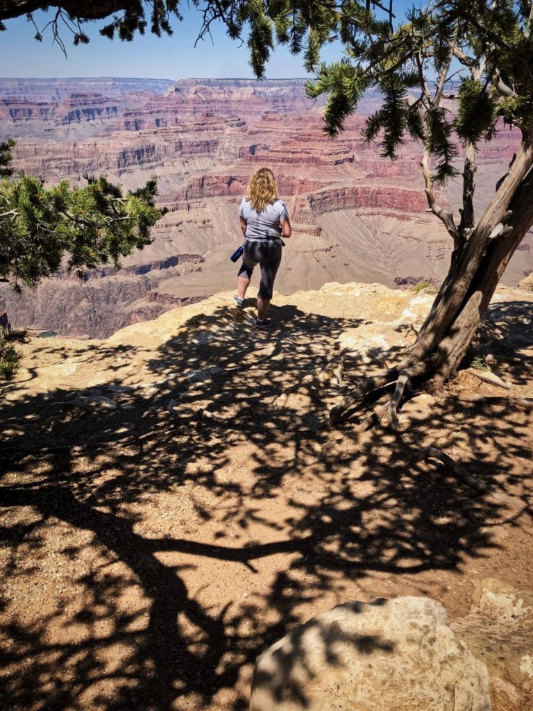 lady standing on the edge looking out over the grand canyon